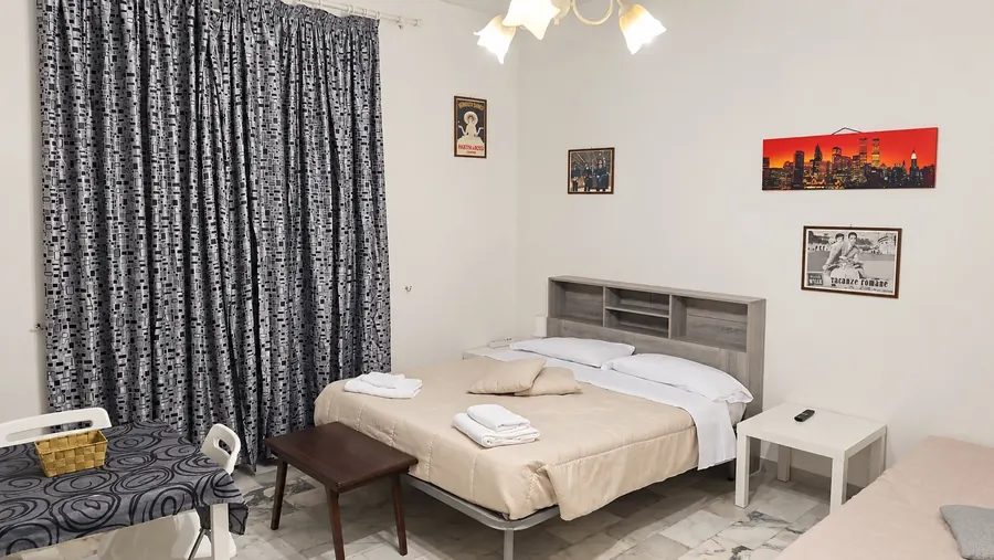 Camera con le tende grigie, la testiera grigia e il quadro rosso