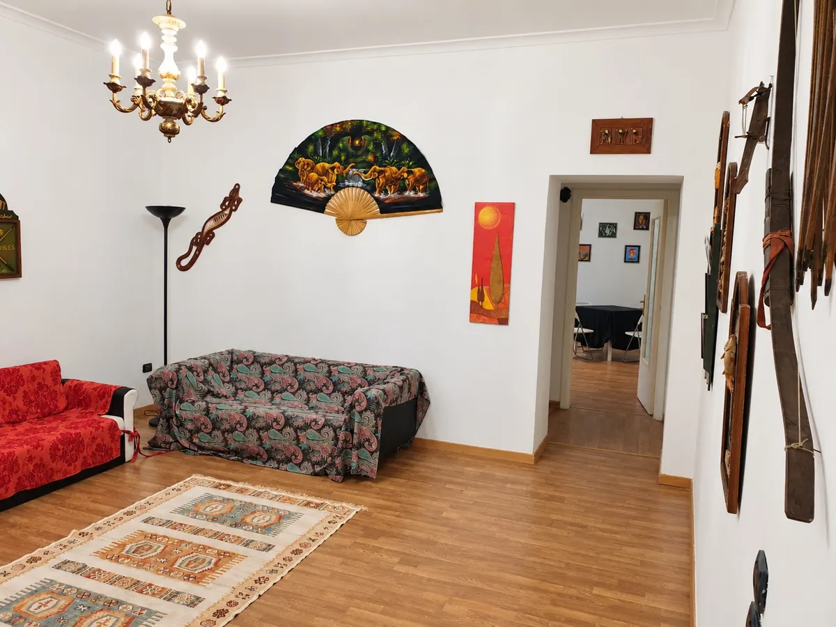 Der offene Wohnbereich mit den zwei Sofas, dem bemalten Fächer und dem mehrarmigen Kronleuchter